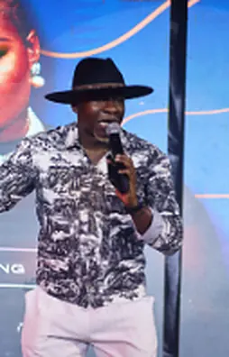 Theo performing in a monochrome print shirt and black hat